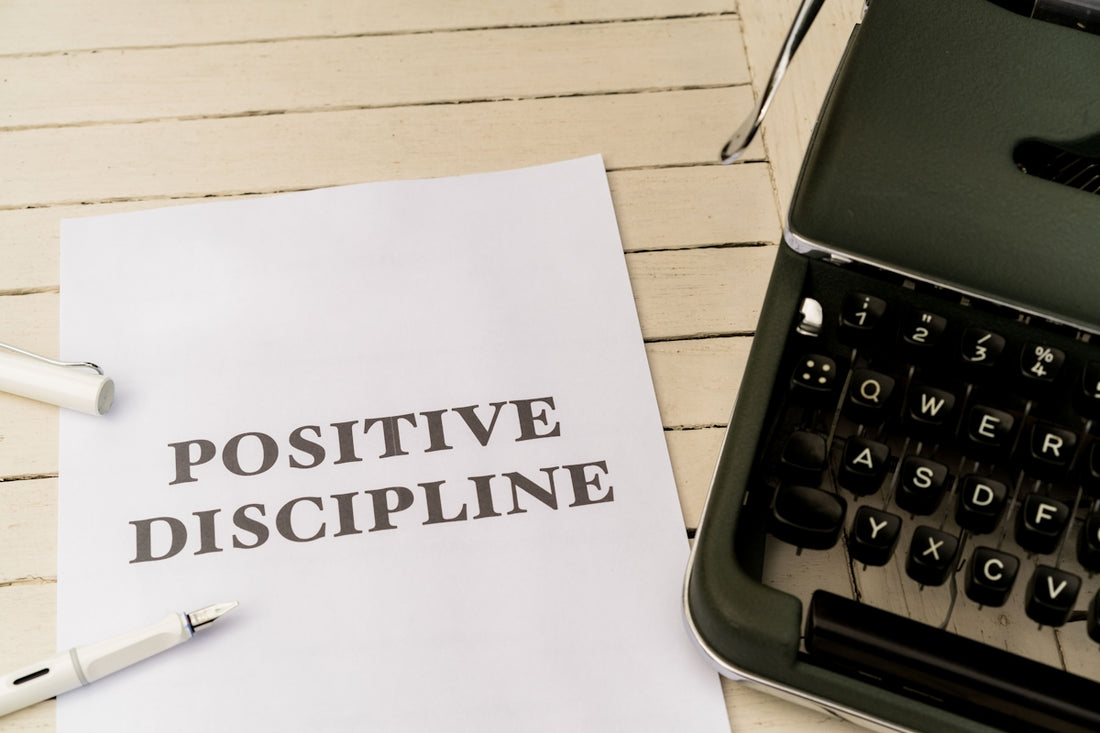 a piece of paper that says positive discipline next to a typewriter
